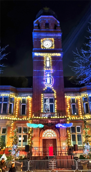 A town hall illuminated for a Christmas Light Switch-on event with laser projected countdown.
