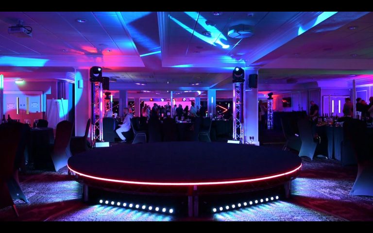 Futuristic-themed corporate event at the 1883 Suite in Stockport County Football Club with modern stage and lighting design