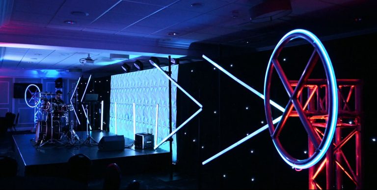 Futuristic-themed corporate event at the 1883 Suite in Stockport County Football Club with modern stage and lighting design