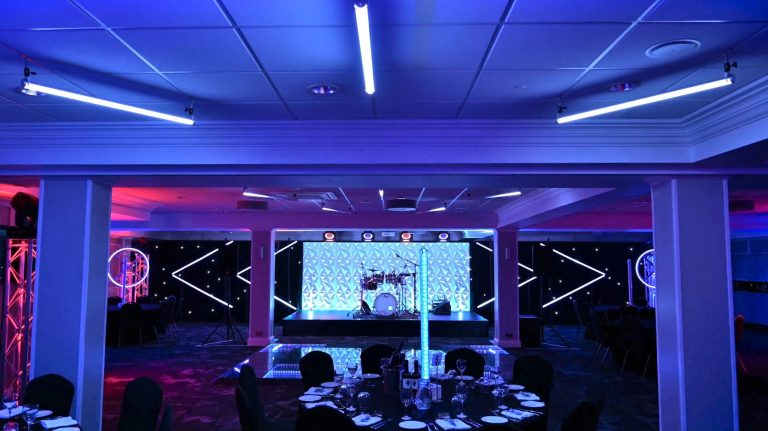 Futuristic-themed corporate event at the 1883 Suite in Stockport County Football Club with modern stage and lighting design
